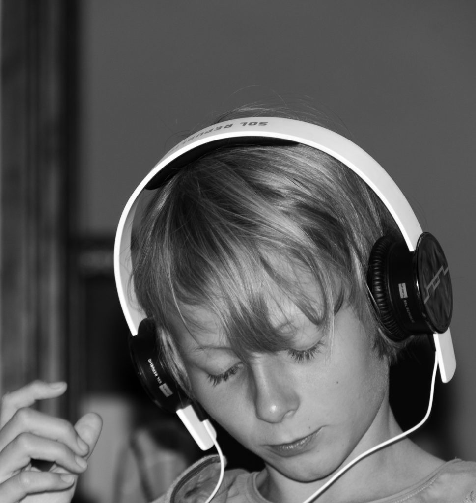Kopfportrait eines jungen Mädchens mit übergrossen Kopfhörern