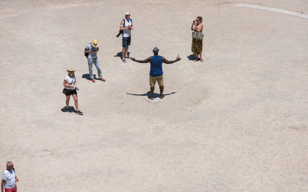 Touristen im Amphitheater von den obersten Rängen mit Teleobjektiv fotografiert