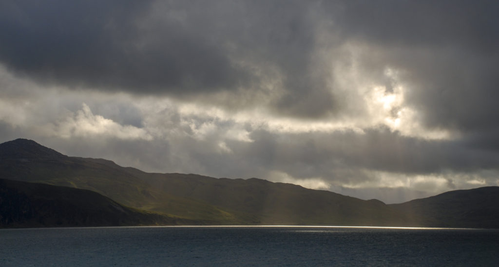 hauchdünner Lichtstreifen auf dem Wasser vor einer schottischen Insel