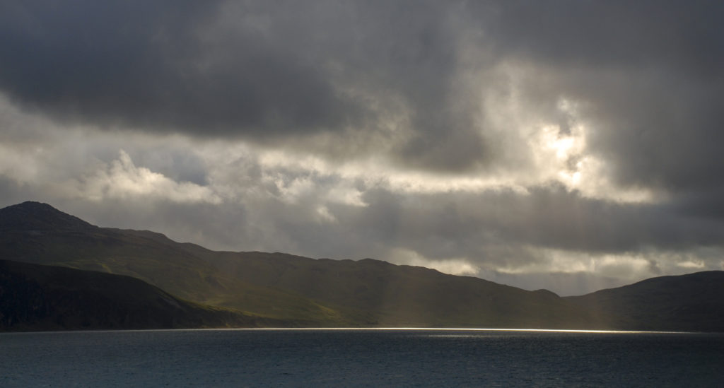 Schottland hauchdünner Lichtstreifen auf dem Wasser vor einer schottischen Insel