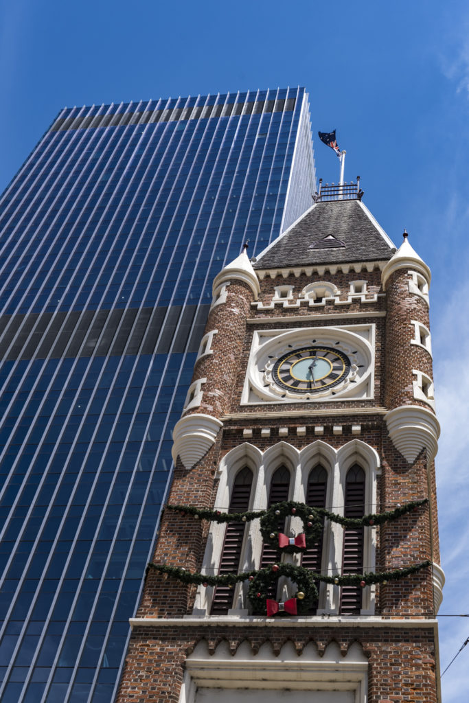 Gegensatz zwischen modernem Hochhaus und altem Kirchturm in Perth