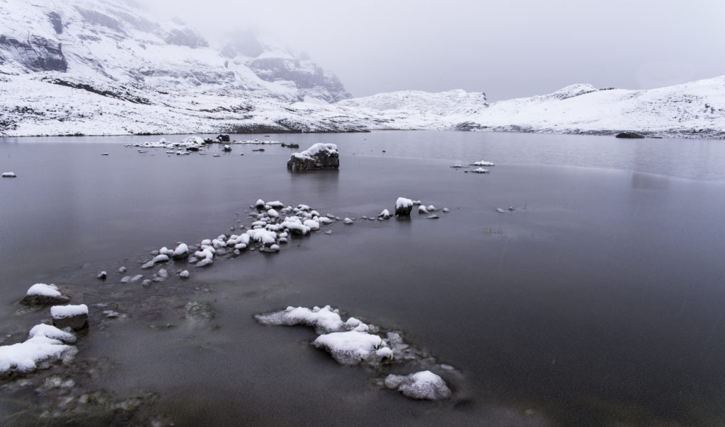 Der Glattalp-See im Nebel und frisch verschneitem Ufer