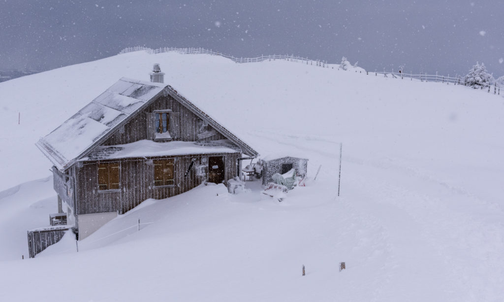 eingeschneites Haus auf der Rigi während einem Schneesturm