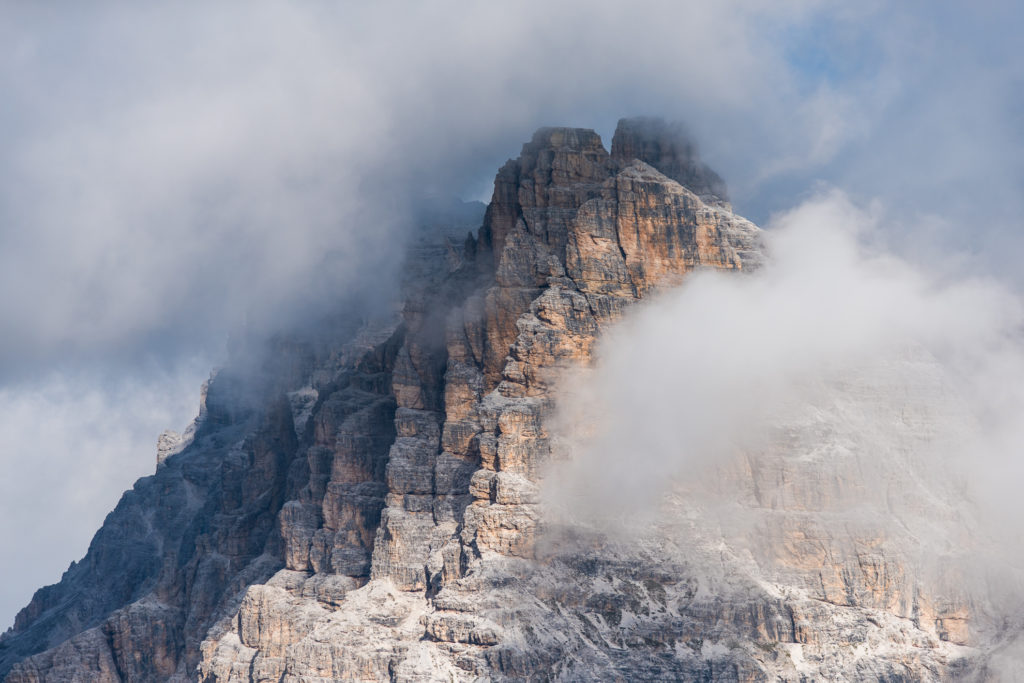 eingehüllt in dichte Wolken zeigt sich unnahbar der steile Gipfel des Zwölferkofels