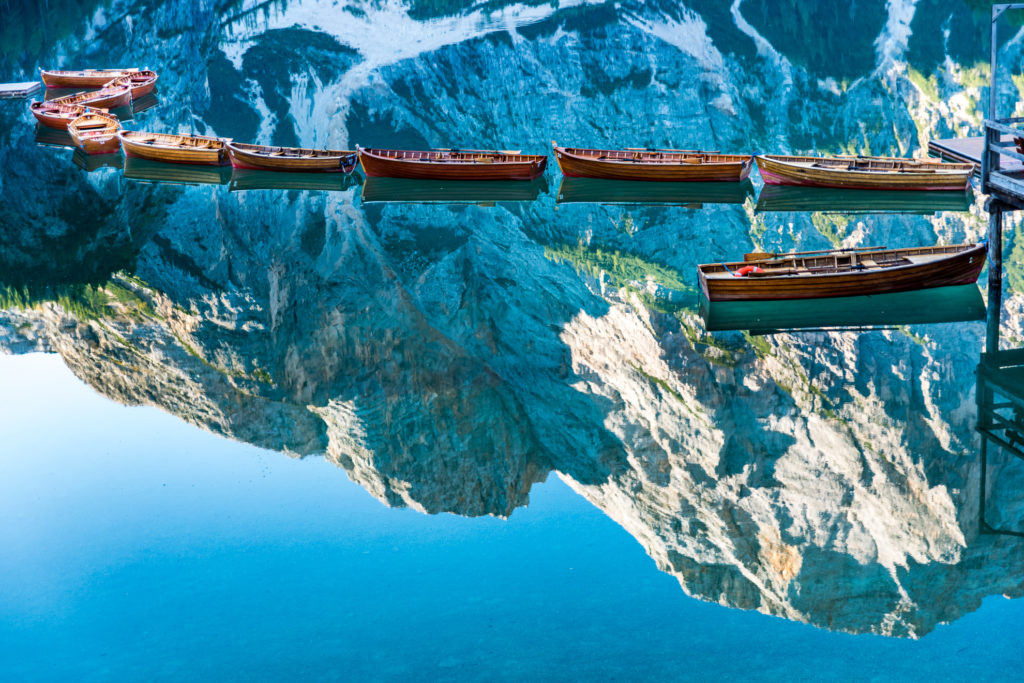 vert&auml;ute Ruderboote auf dem spiegelglatten Pragser Wildsee, Unten und Oben geraten durcheinander