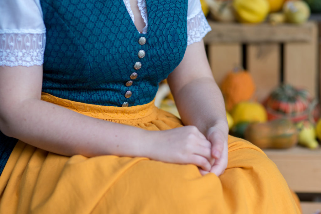 Portrait Fotografie, Available Light: Brust-Ausschnitt eines blau-gelbes Dirndls