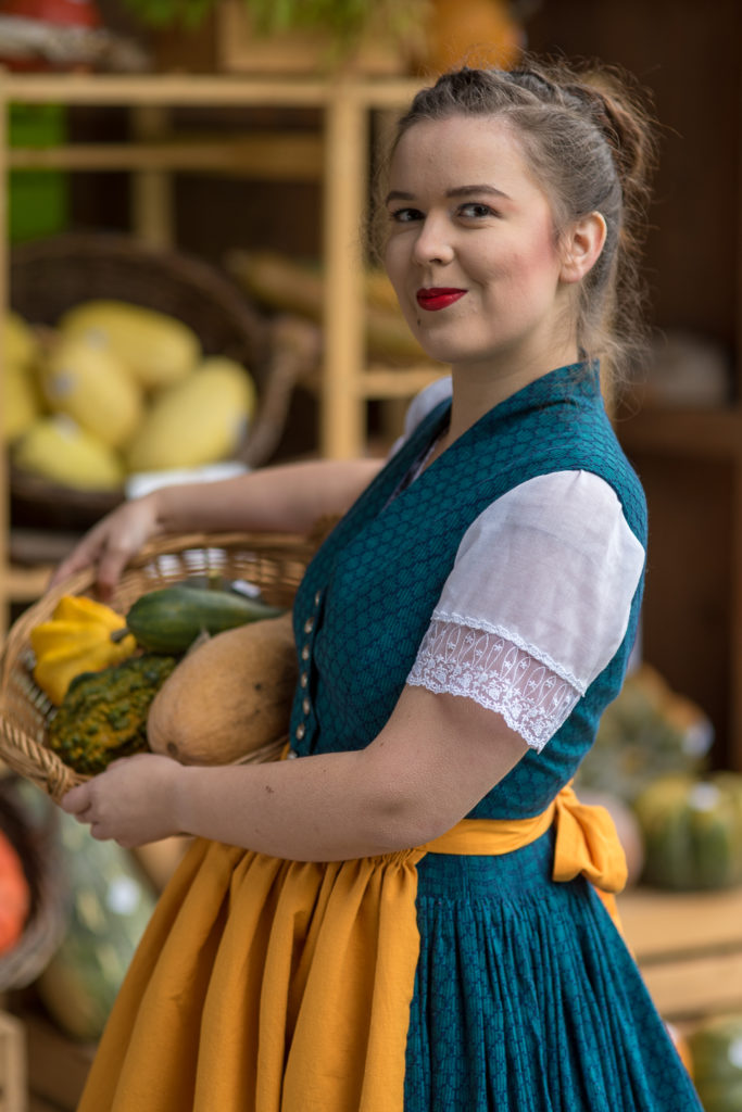 Portrait Fotografie, Available Light: blau-gelbes Dirndl im Halbportrait mit K&uuml;rbiskorb