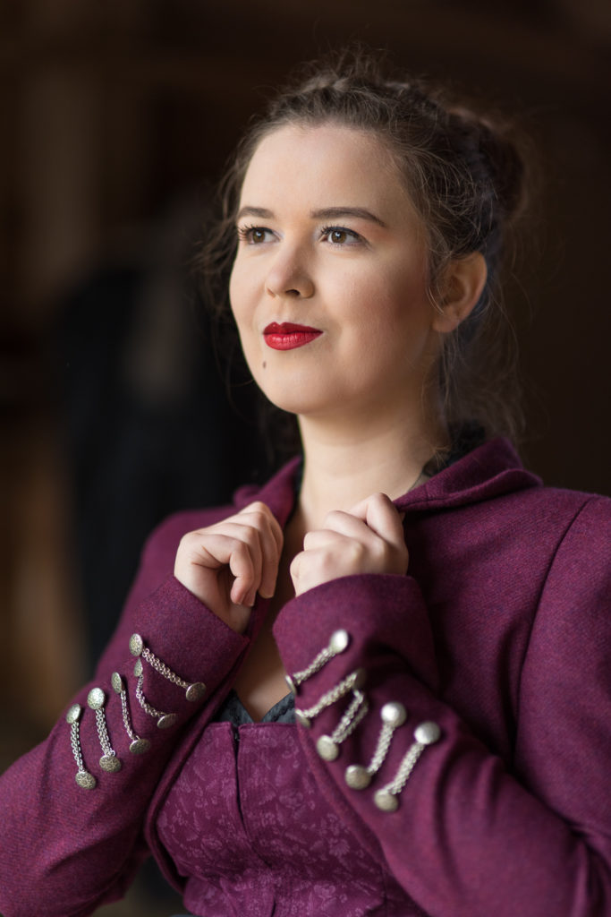 Portrait Fotografie, Available Light: klassisches, dunkelrotes Dirndl im Brustportrait