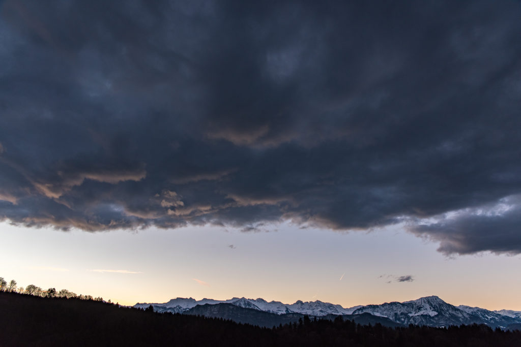 Bergkette im fr&uuml;hen Morgenlicht mit dunklen Wolken