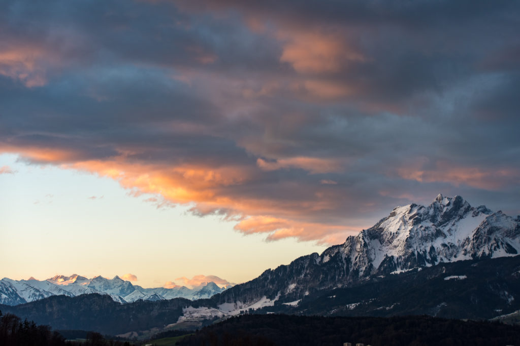 tief verschneite Berge kurz vor Sonnenaufgang mit roten Wolken