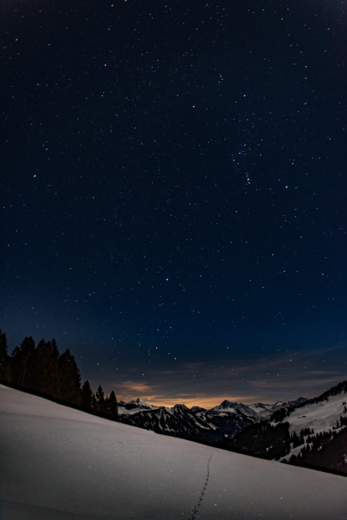 sternenklare Winternacht, Berggipfel im Abendglühen