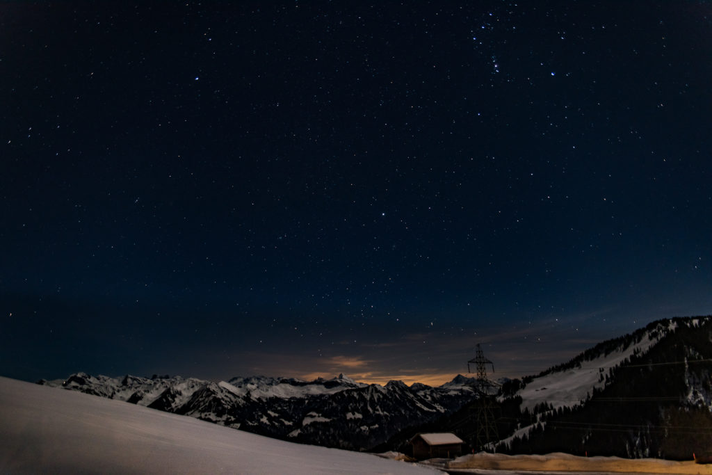 sternenklare Winternacht, Berggipfel im Abendglühen
