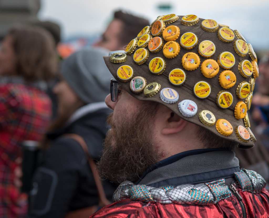 Luzerner Fasnacht, Kopf mit Hut, der mit Kronenkorken von Bierflaschen geschm&uuml;ckt ist