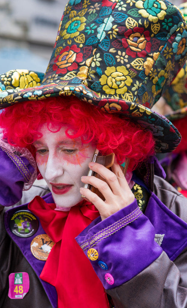 Luzerner Fasnacht, geschmückter Damenkopf mit Hut mit dem Handy am Telefonieren