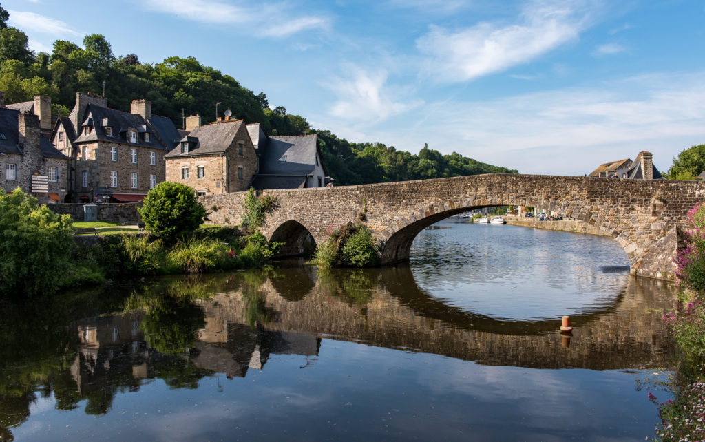 Breizh, Bretagne, alte Steinbr&uuml;cke im Hafen von Dinan, sich im Wasser spiegelnd, im Abendlicht