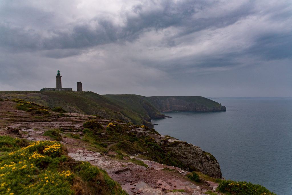 Breizh, Bretagne, Cap Fréhel, Leuchtturm an der Steilküste bei regnerischem Wetter und tiefhängenden Wolken