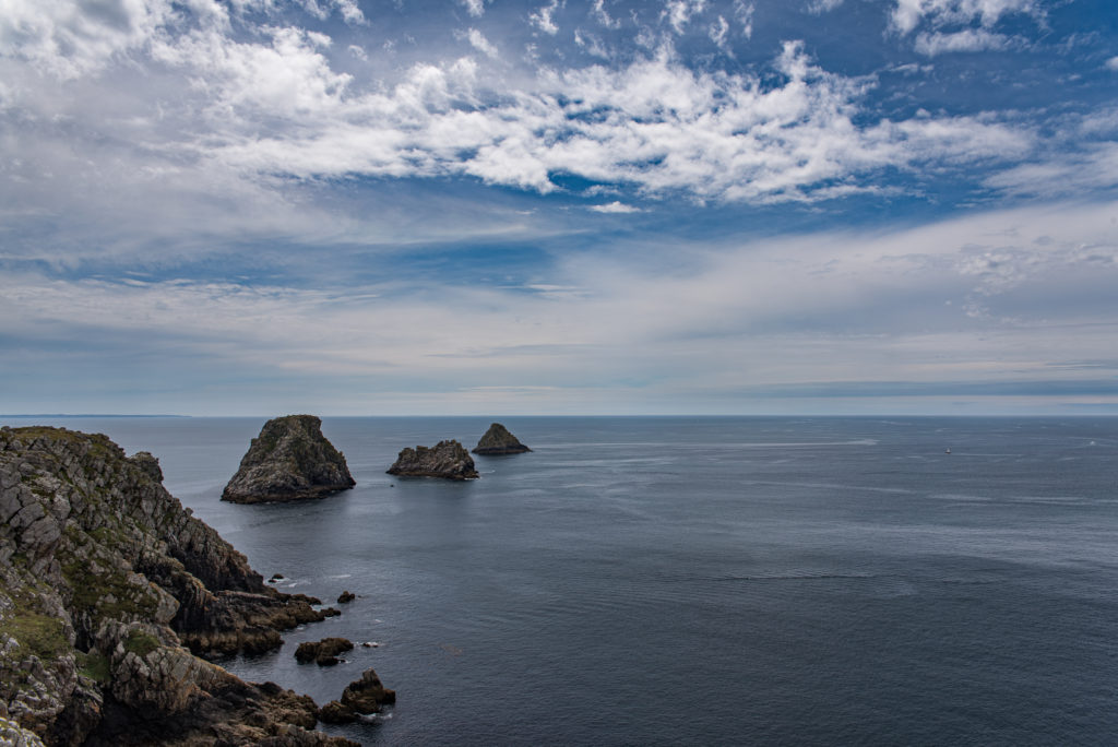 Breizh, Bretagne, Pointe de Penhir, Felst&uuml;rme im Meer bei bew&ouml;lktem Himmel und ruhigem Meer