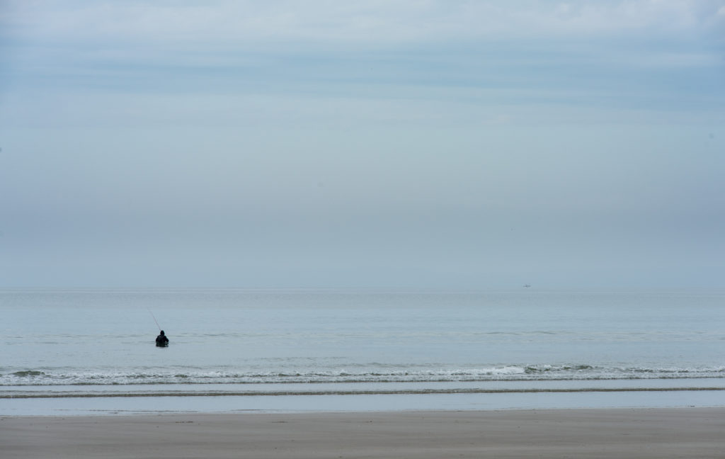Breizh, Bretagne, Saint Anne la Palude, einsamer Fischer der bis zur Brust im Meer steht