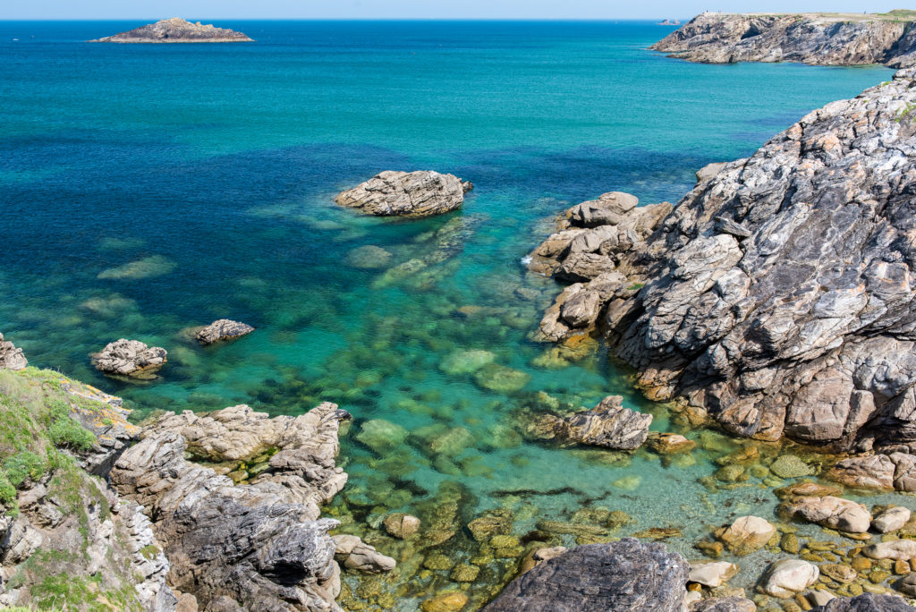 Breizh, Bretagne, Côte Sauvage auf der Halbinsel Quiberon, blau-grünes, glasklares Meer und steile Klippen bei Sonnenschein