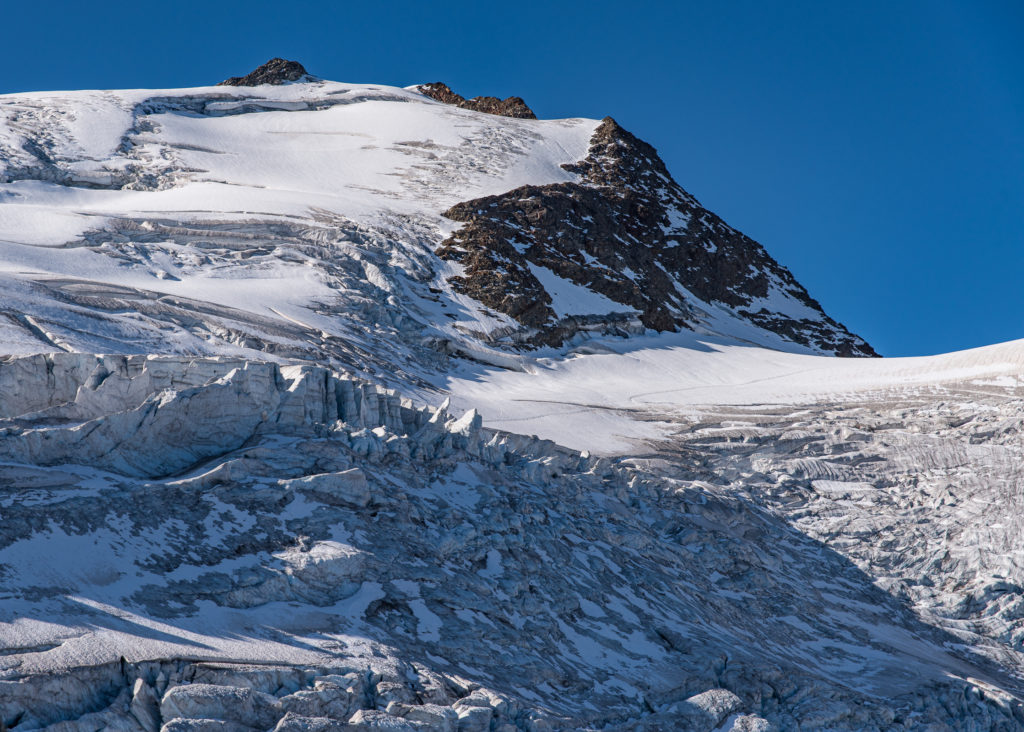 Bergspitze, im Vordergrund Gletscherabbruch im Sonnenlicht