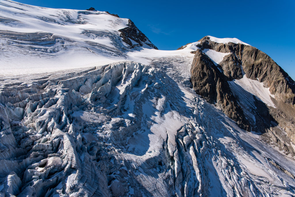 Gletscherabbruch mit Spalten, im Hintergrund Berggipfel
