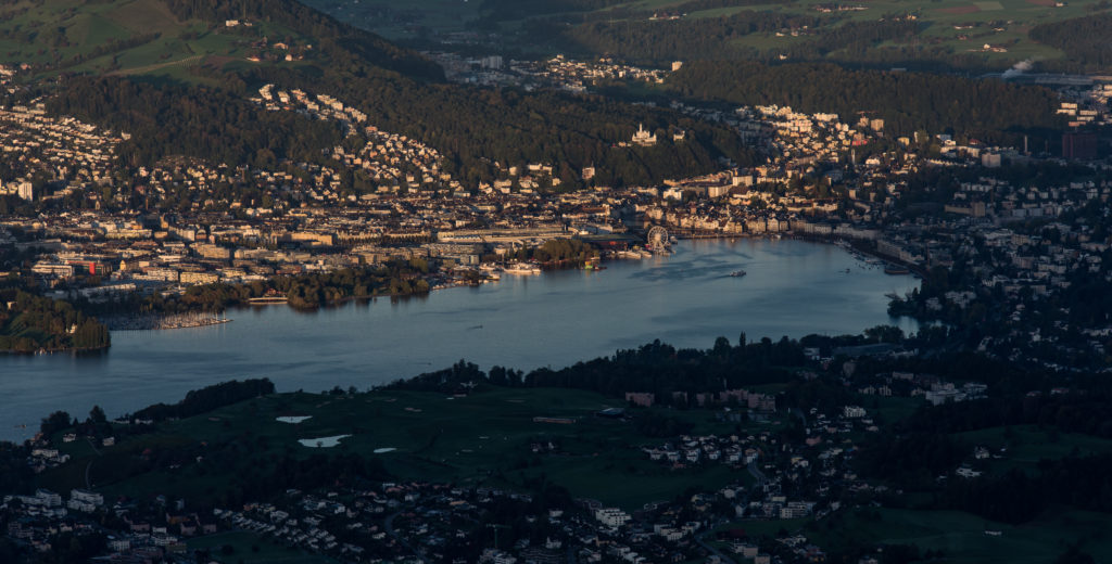 Stadt an der Seebucht, teilweise im ersten Morgenlicht, teilweise noch im Schatten