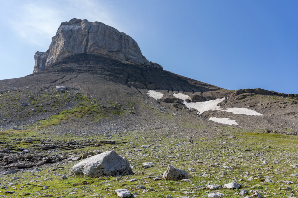 Felsturm umgeben von Geröllfeldern und einzelnen Schneefeldern
