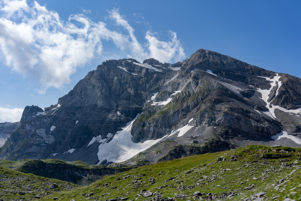 Felsmassiv mit Schneefeldern und blauem Himmel mit weissen Quellwolken