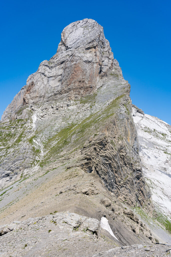einzelner steiler Berggipfel vor blauem Himmel