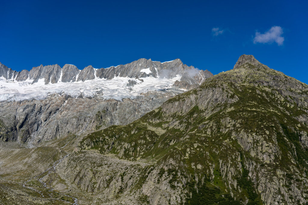 Berggipfel mit Gletschern im klaren Sonnenlicht und blauem Himmel