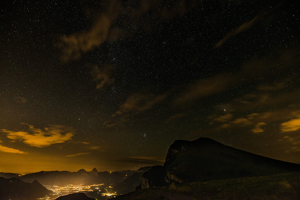 Sternenhimmel mit leuchtender Stadt im Hintergrund