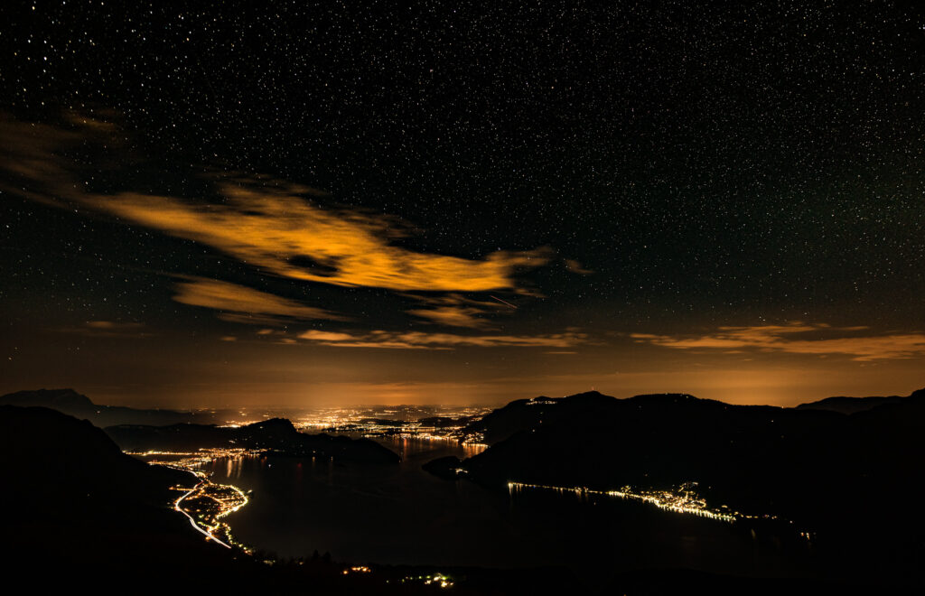Luzern in der Nacht mit Lichtern entlang dem Seeufer unter klarem Sternenhimmel